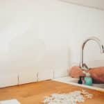 person holding gray curved faucet