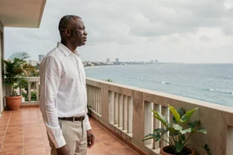 Homme sénégalais sur la terrasse d'un appartement moderne face à l'océan Atlantique à Dakar